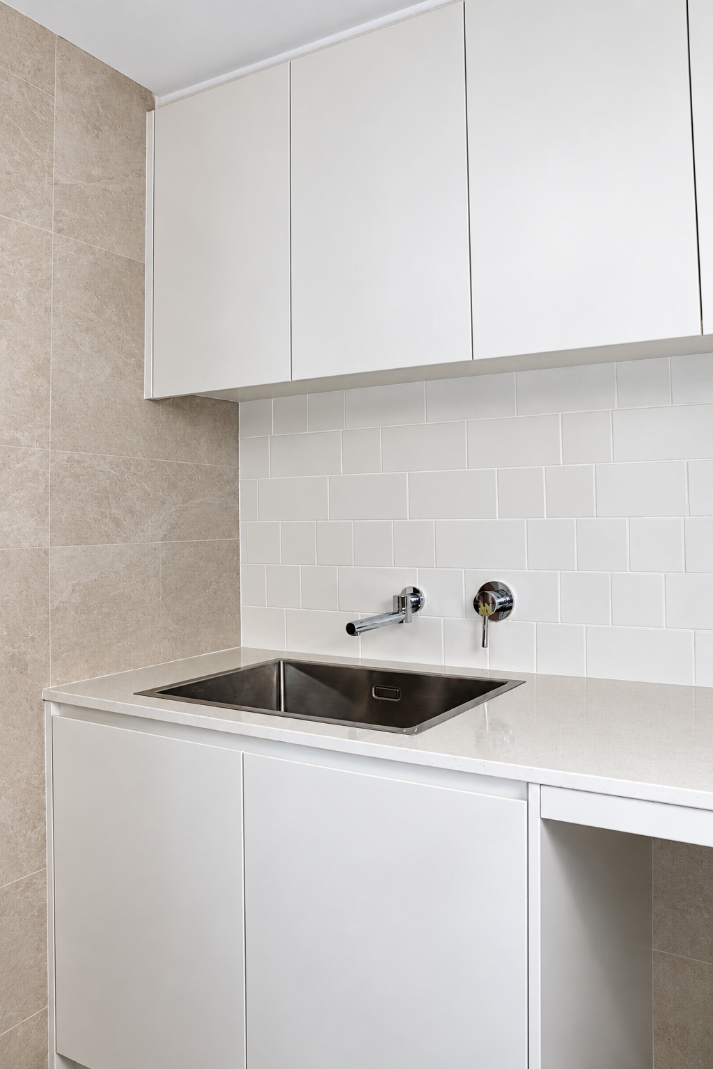 Laundry with white cabinetry, subway tile splashback and an undermount stainless sink